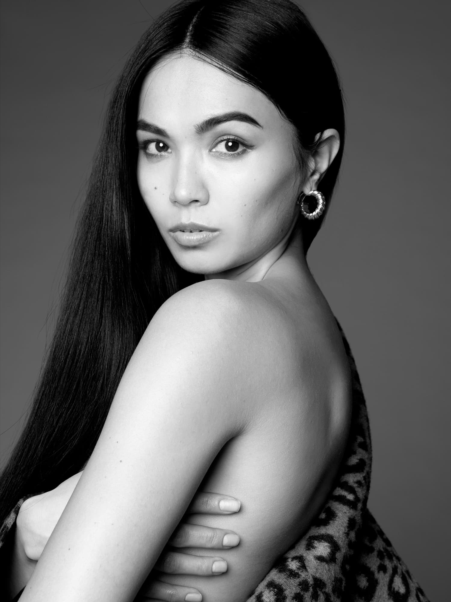 Black-and-white close-up of Shirin Hojayeva with sleek hair and a leopard wrap, conveying refined sophistication.